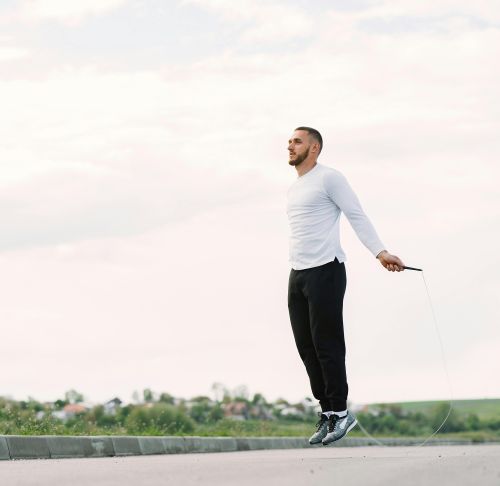Man performing jump rope exercise outdoors for fitness and healthy lifestyle.