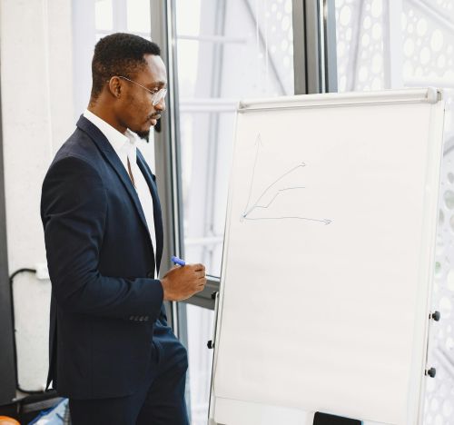 Confident businessman in a suit giving a presentation on growth strategy with a chart on a flipchart.